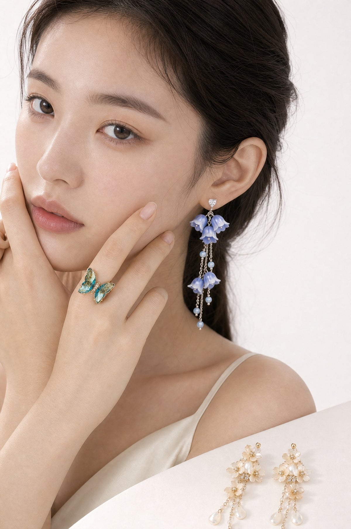 The Lagoon Set worn — earring and ring on the model, the second pair beside her