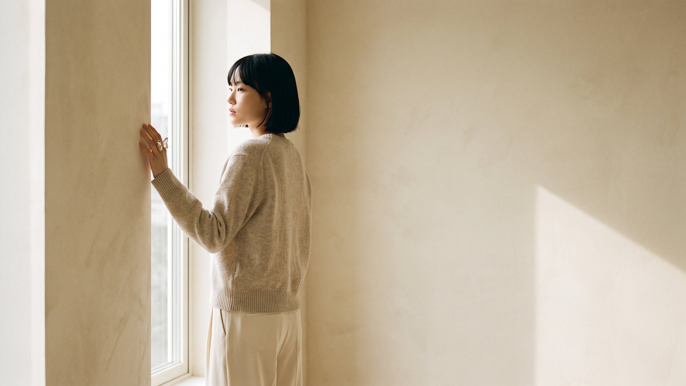 A model standing by a window in daylight, wearing the Nabi Ring in aurora