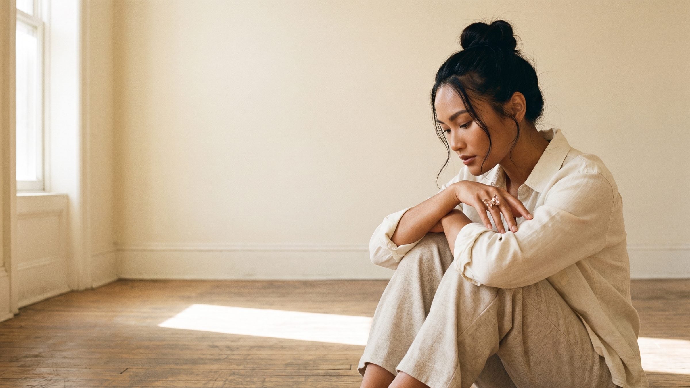 A model seated by a window wearing the Nabi Ring in blush