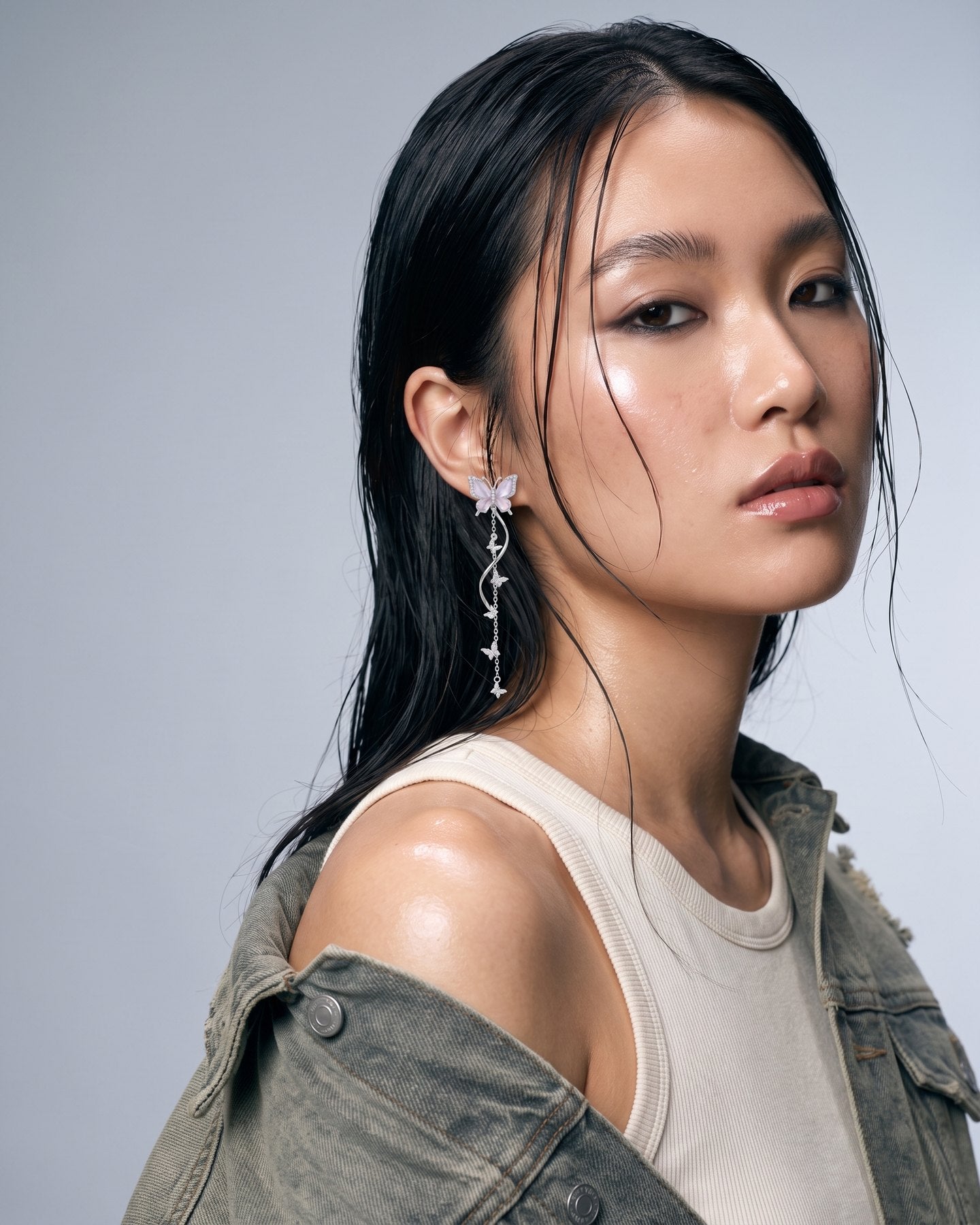 A model wearing the Nabi Earrings in lilac, photographed close to the jaw